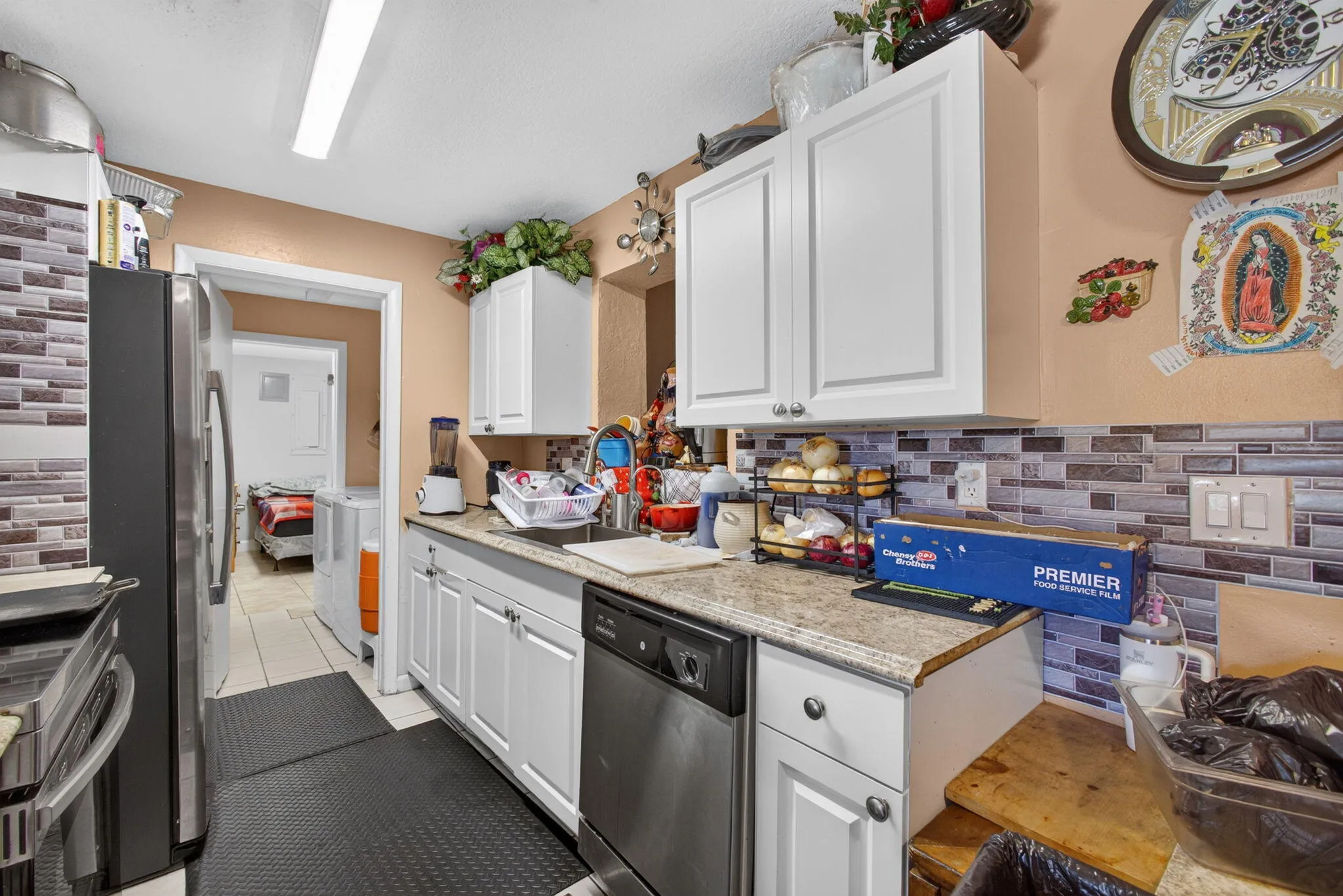 White cabinetry, stone-look countertops, and a full tile backsplash