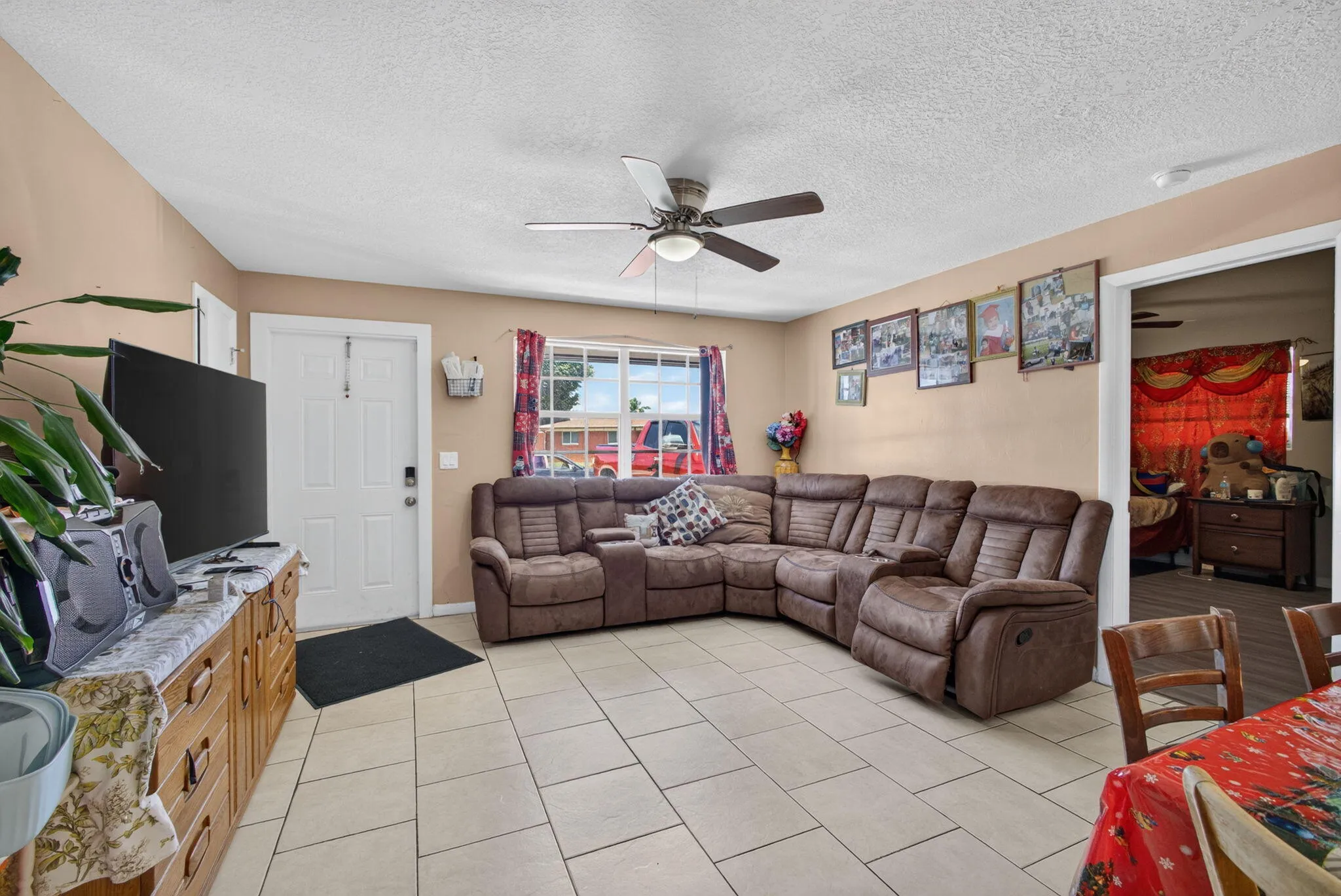 Tiled flooring throughout, neutral tone walls, and a ceiling fan with integrated lighting
