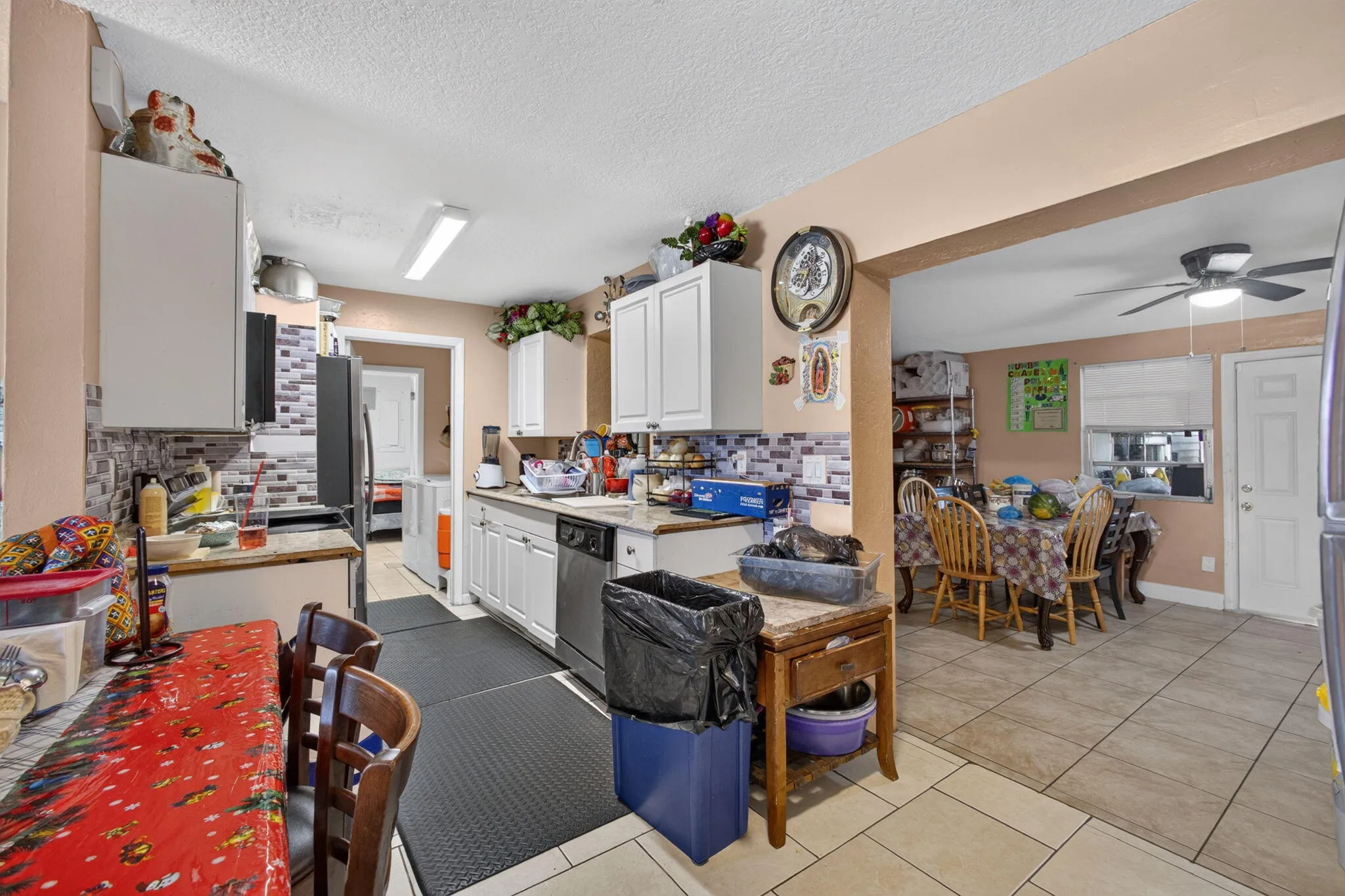 Kitchen featuring white cabinetry, a tile backsplash, and a stainless steel dishwasher