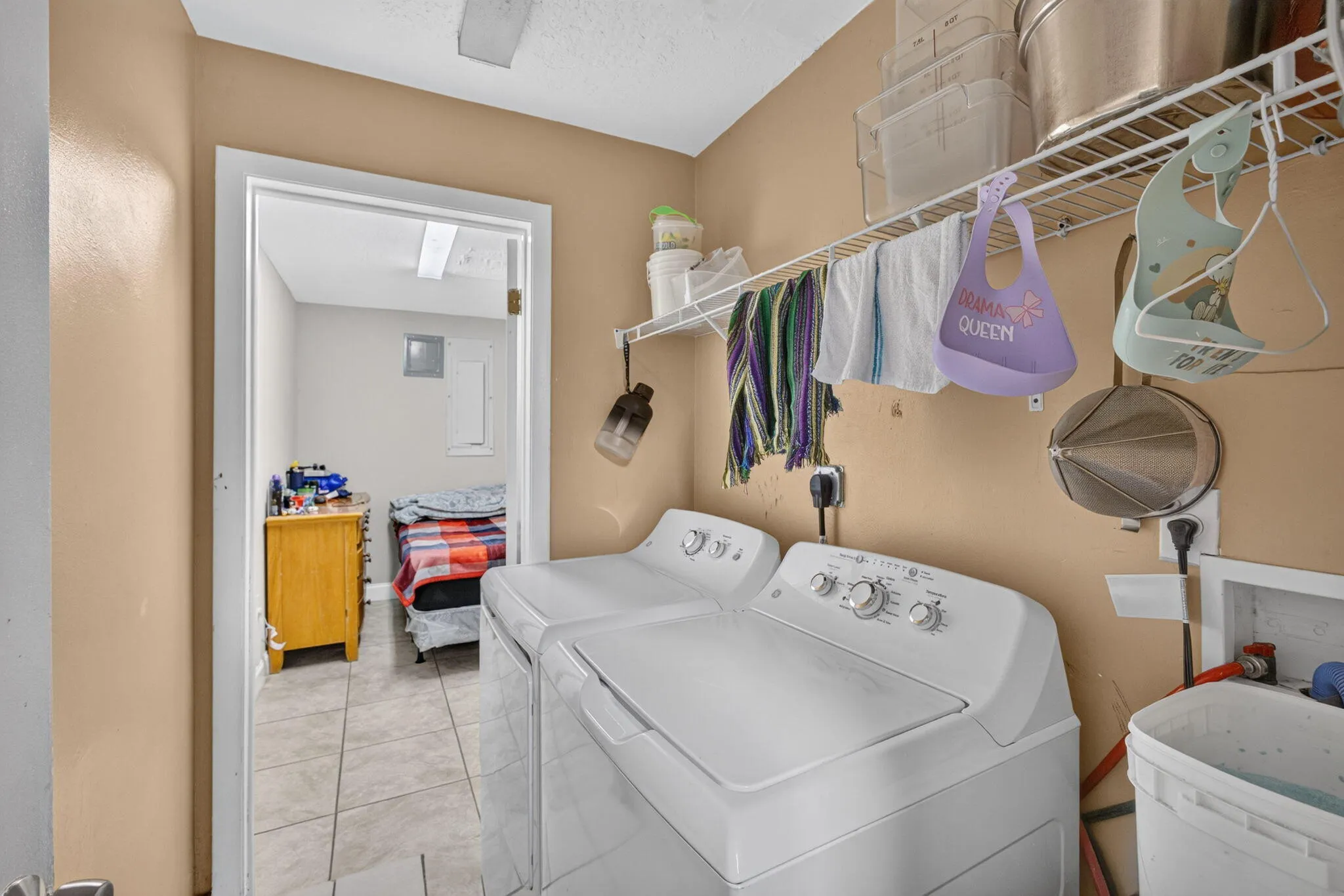 Laundry area with tile flooring and a wire shelving system