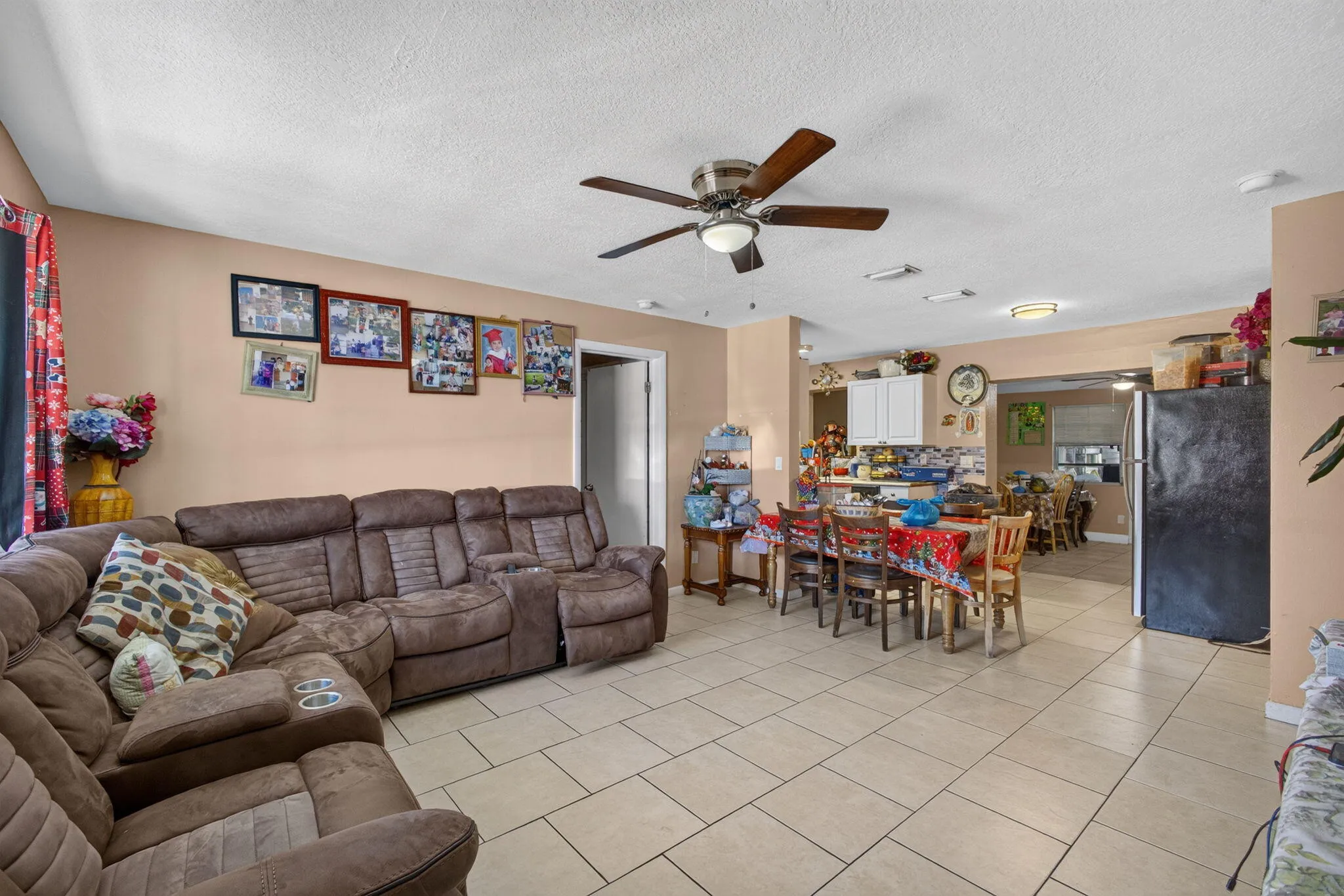 Spacious interior with tile flooring throughout, featuring an open dining area and overhead ceiling fan