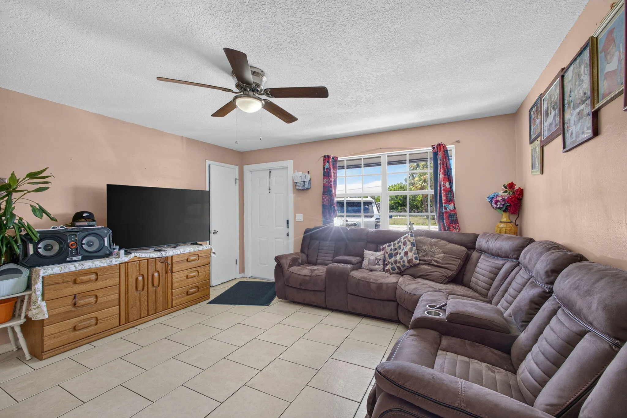 Tile flooring, ceiling fan with integrated lighting, window with exterior exposure, and multiple doors
