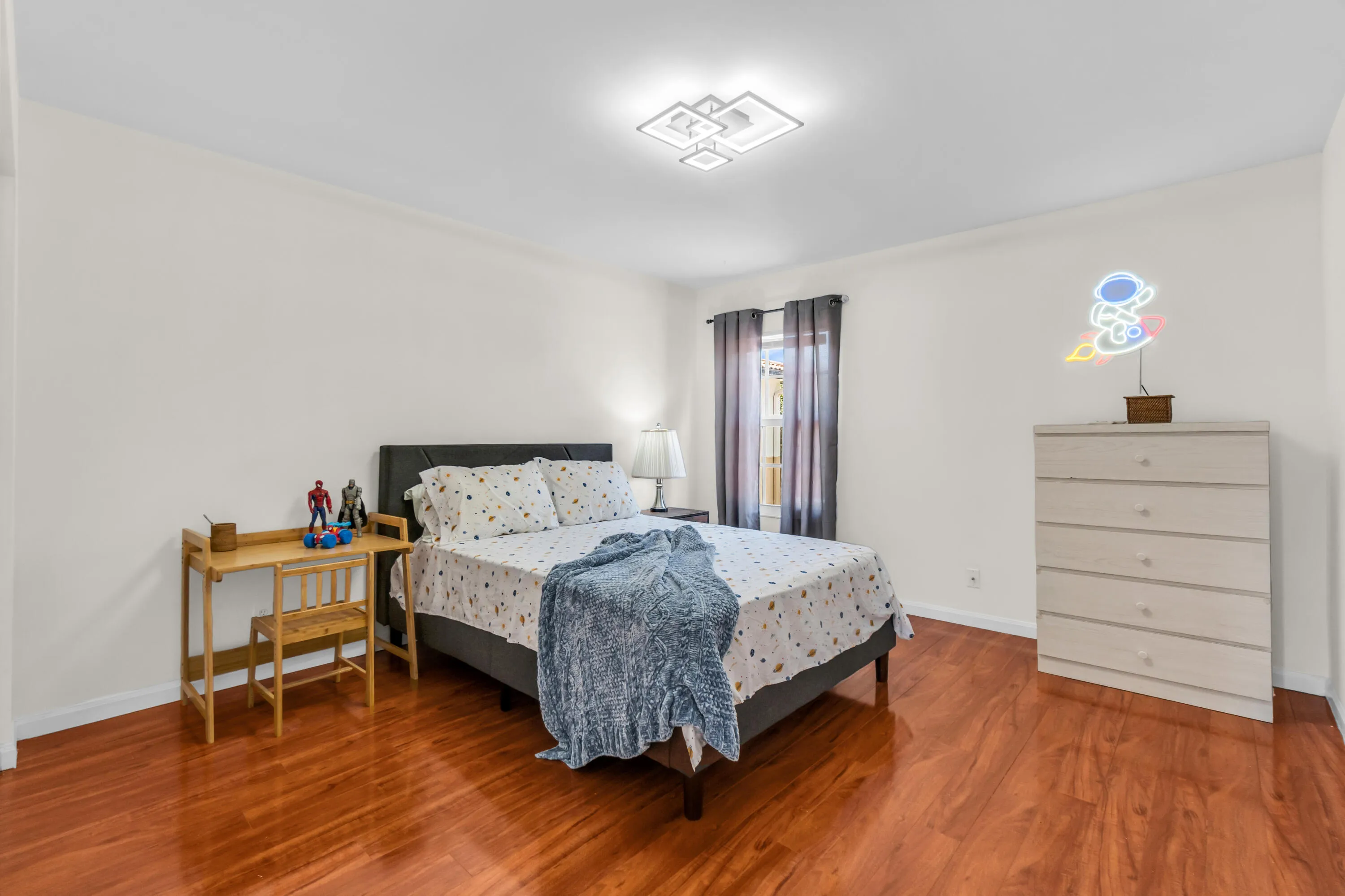 Wood-finish flooring, white walls, and a modern ceiling light fixture