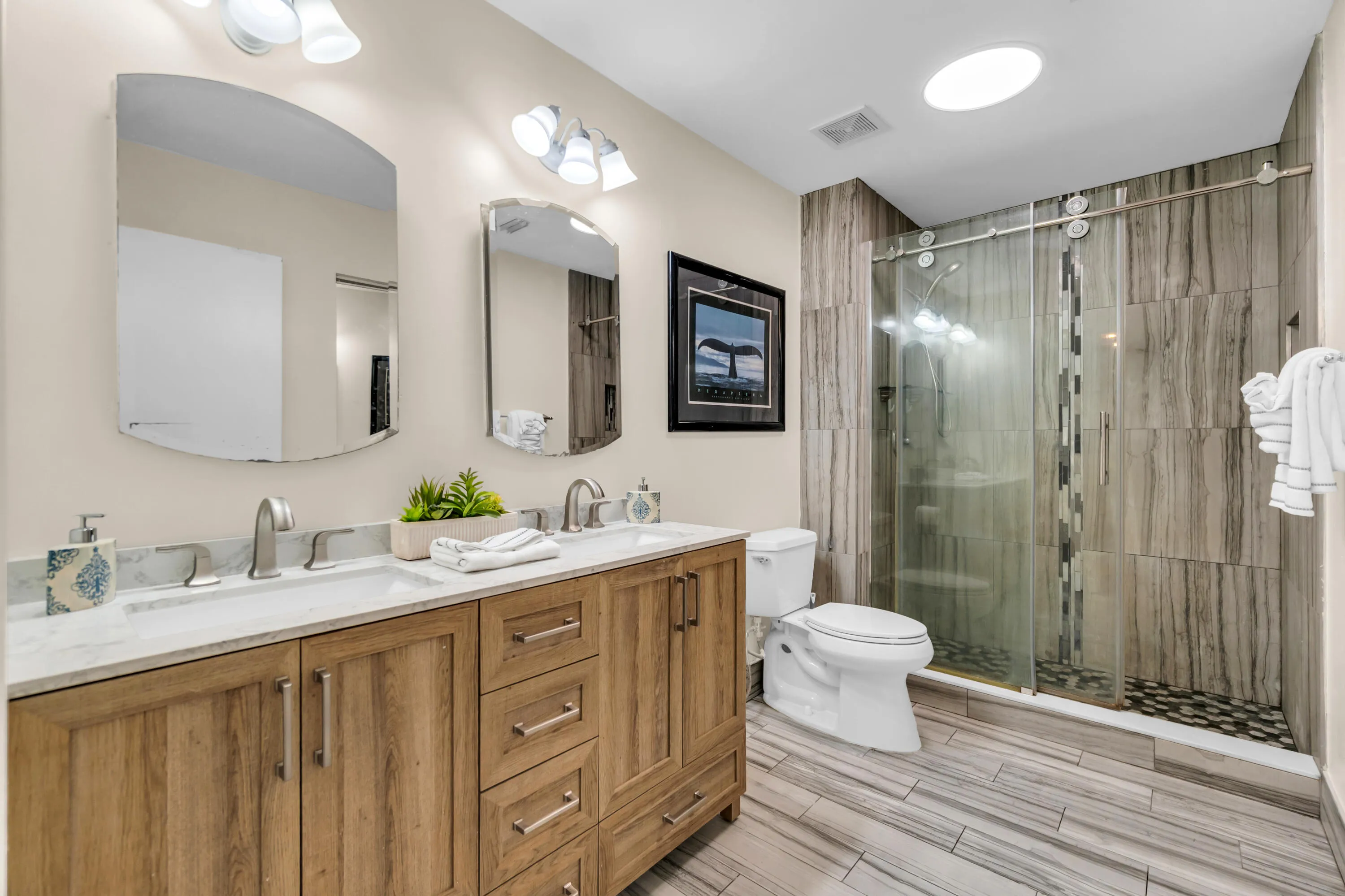 Dual sink vanity with wood-finish cabinetry and white countertops