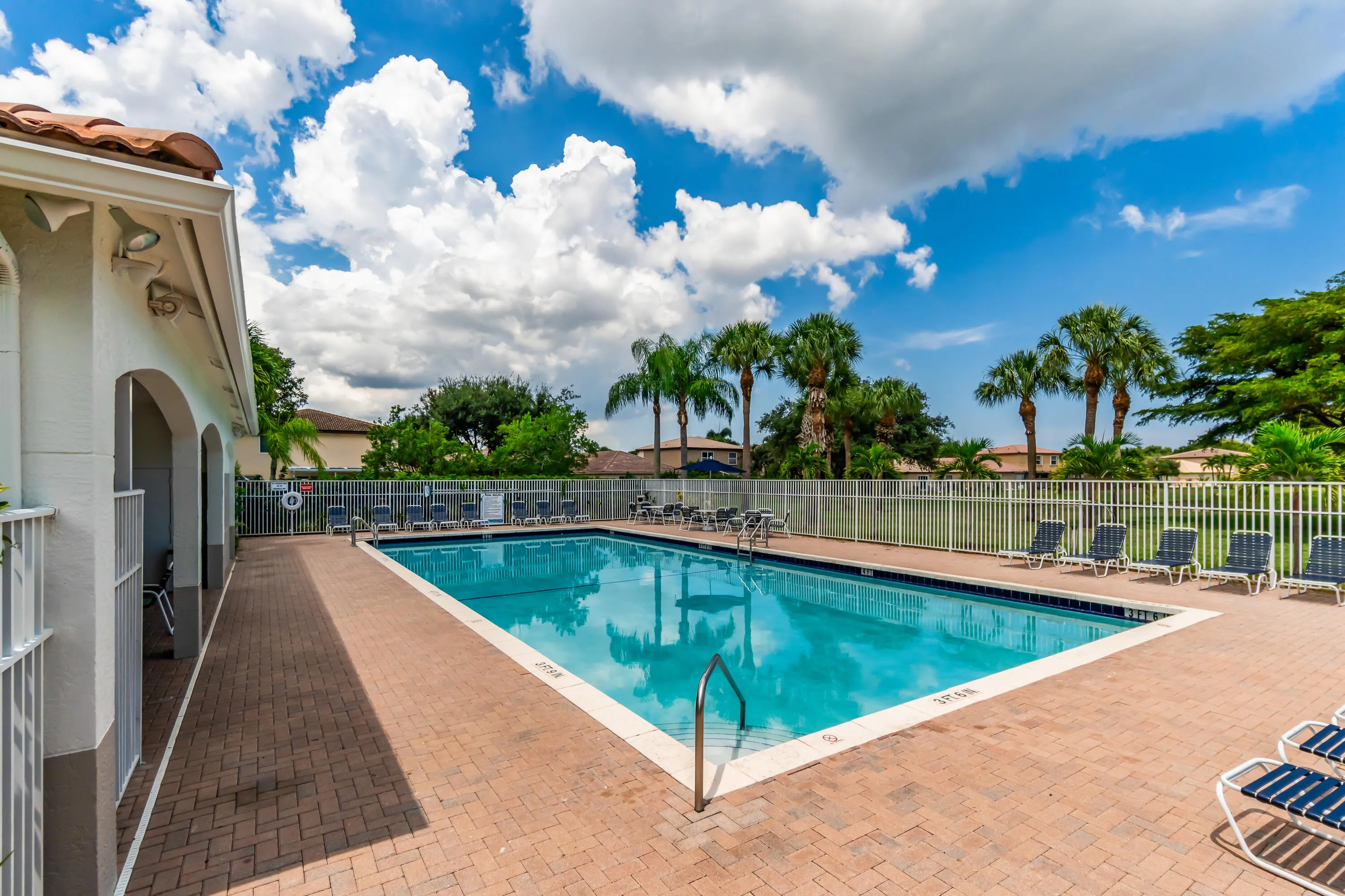 Rectangular swimming pool with a tile border and brick paver surround