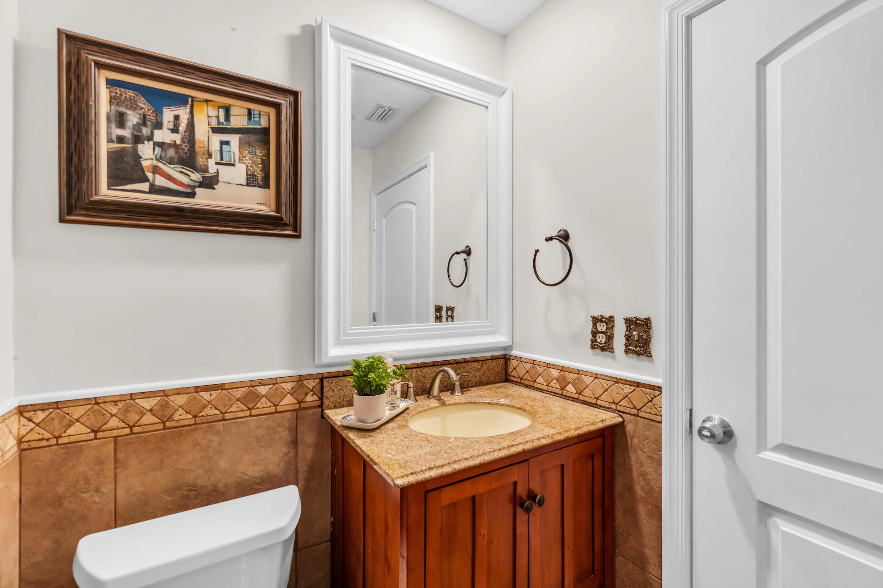 Wood vanity with a drop-in sink and stone countertop