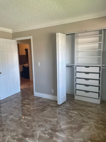 Tile flooring, crown molding, bi-fold closet doors, built-in closet shelving, built-in closet drawers