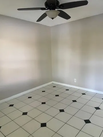 Tile flooring with a black and white checkerboard pattern and a ceiling fan with integrated lighting