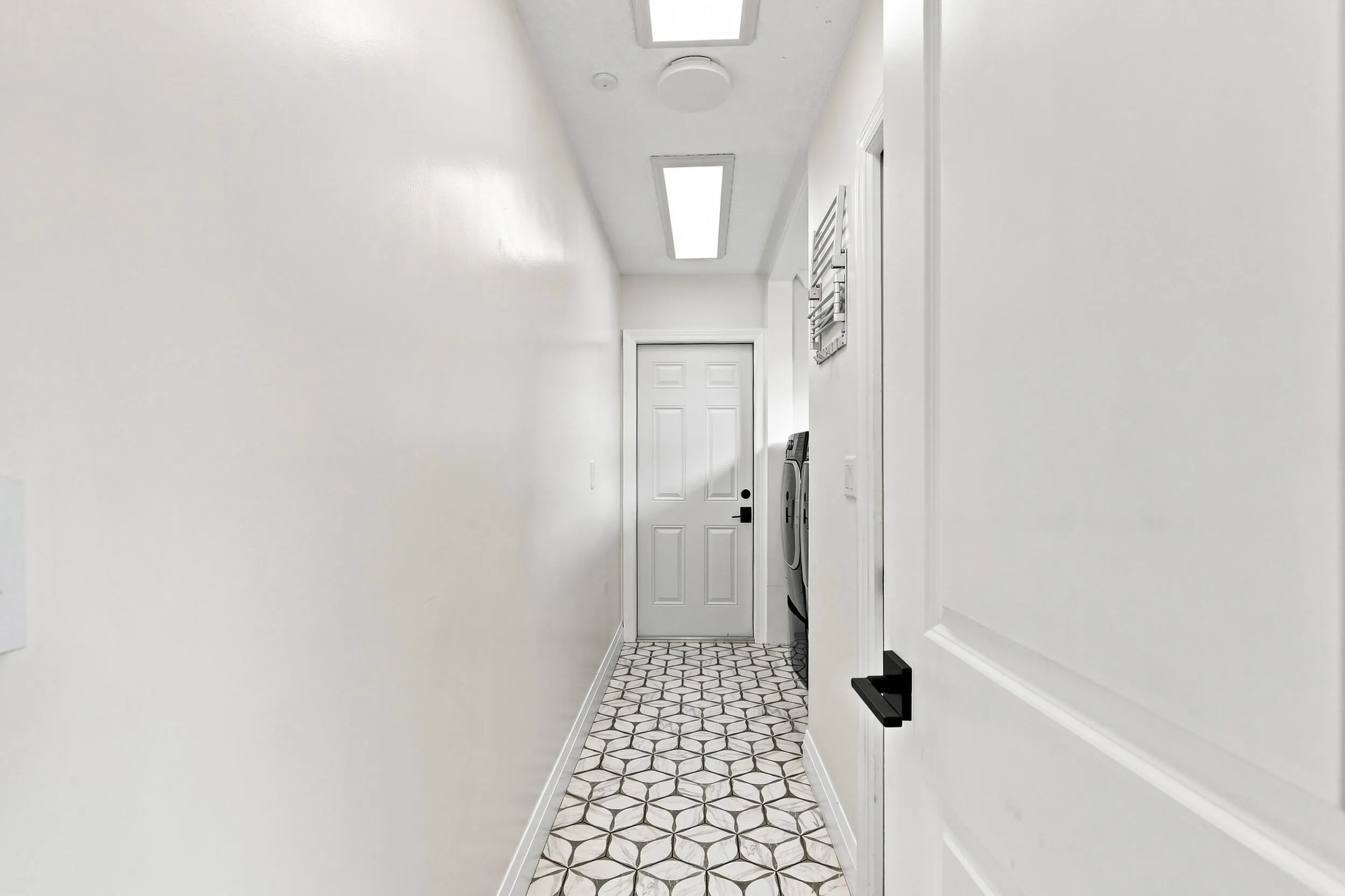 Interior hallway with decorative tile flooring and a bright, clean finish.