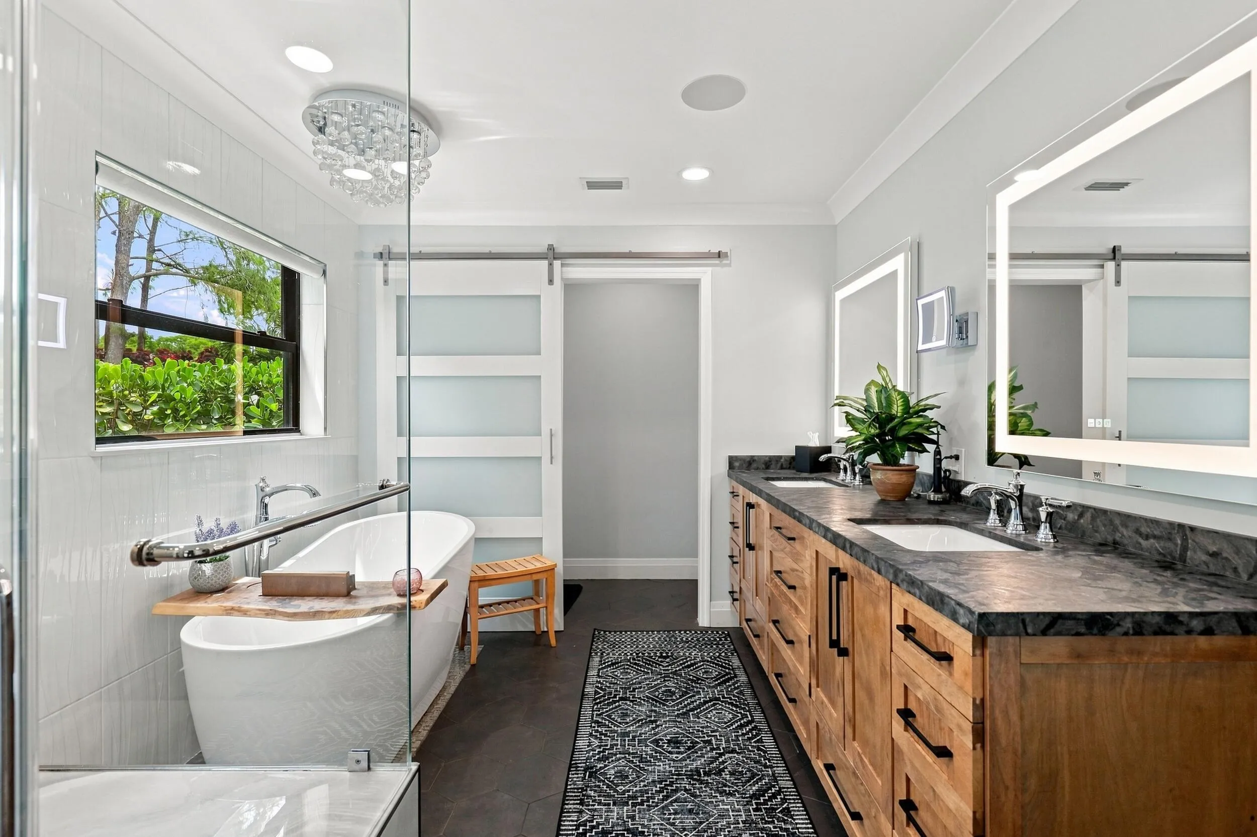 Beautifully appointed primary bathroom with a freestanding tub, glass shower, dual vanity, and abundant natural light.
