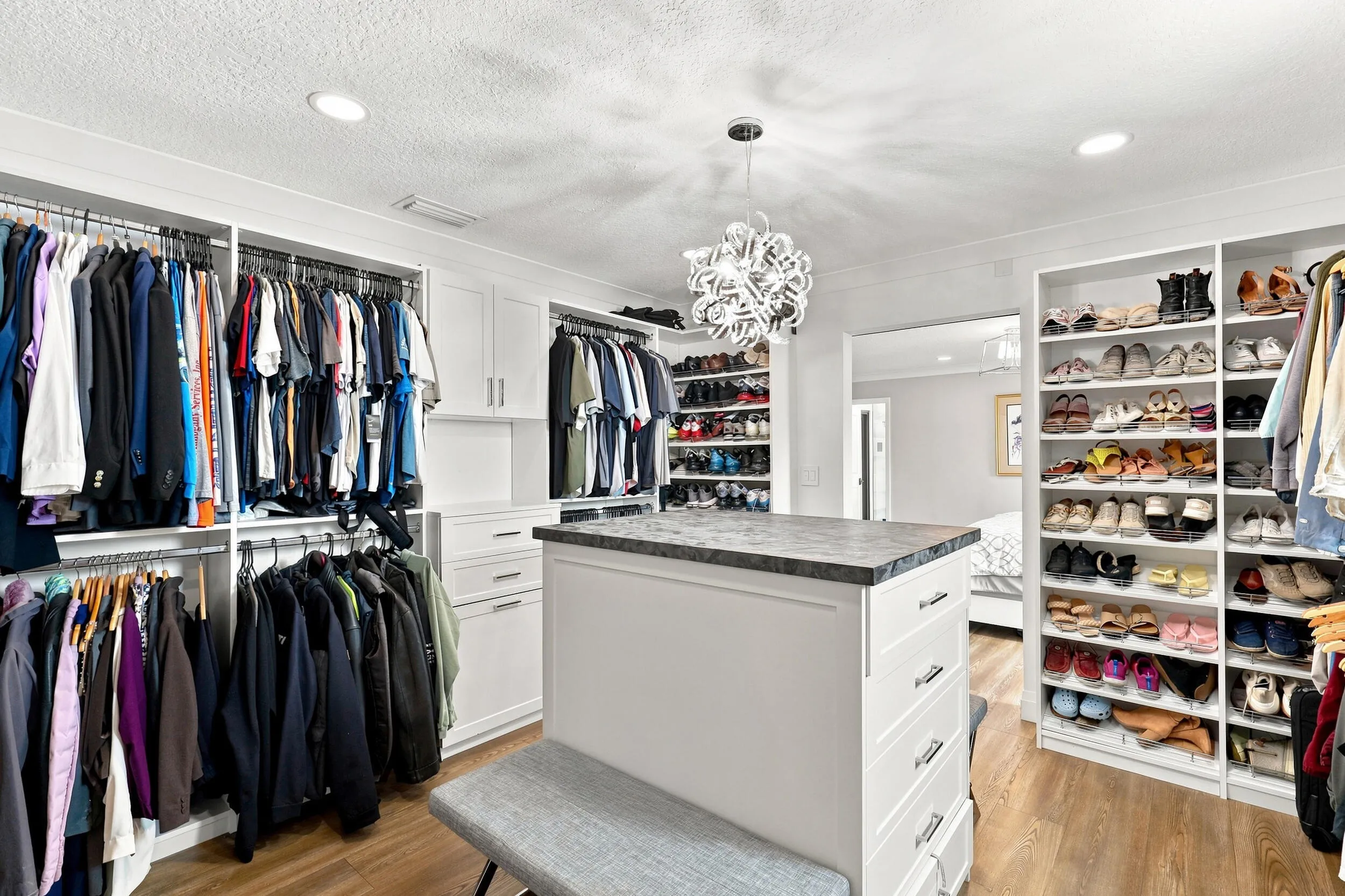 Additional view showcasing the extensive custom shelving, cabinetry, and center storage island.
