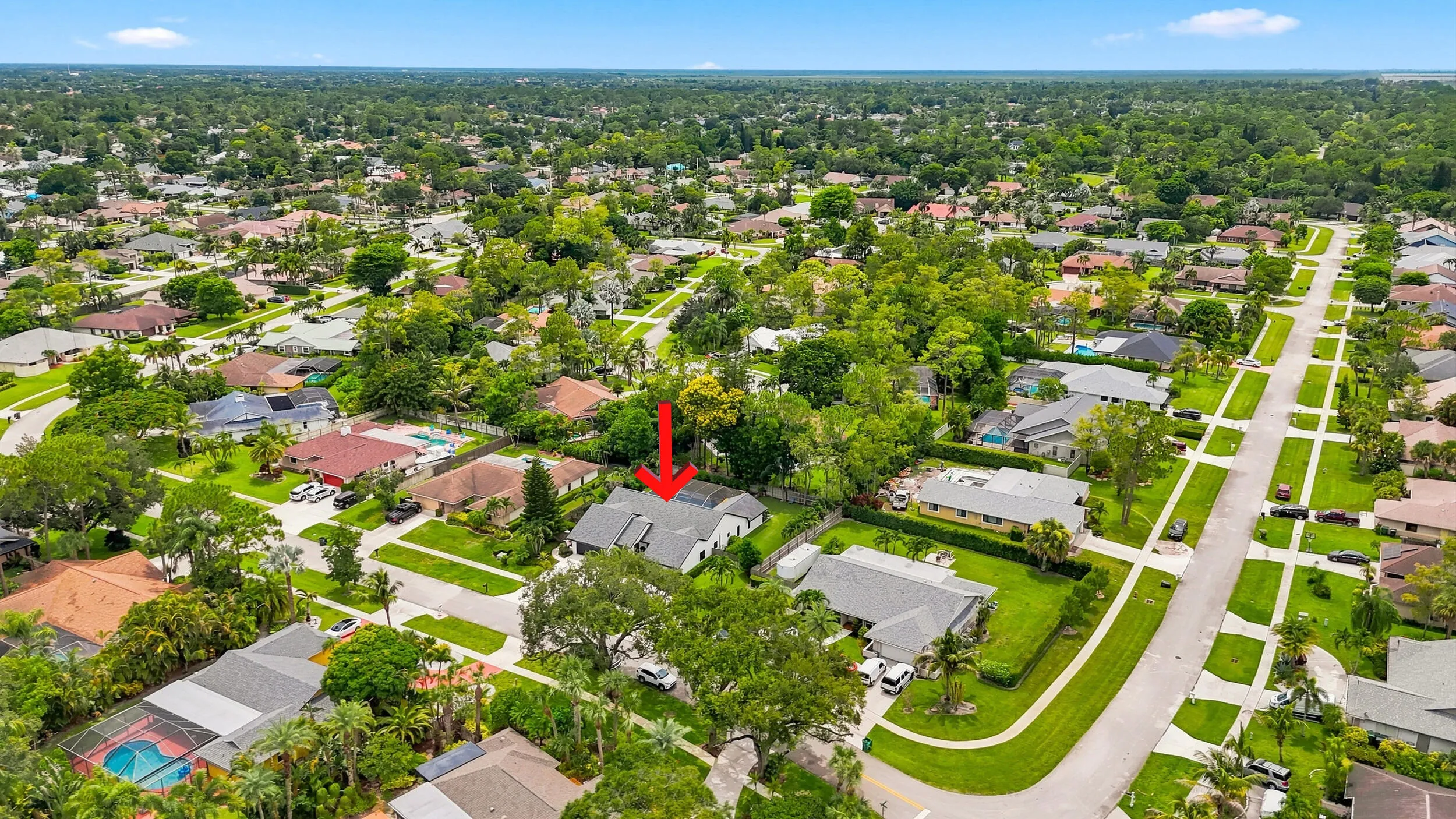 Wide aerial view showing the home’s location within the surrounding residential community.