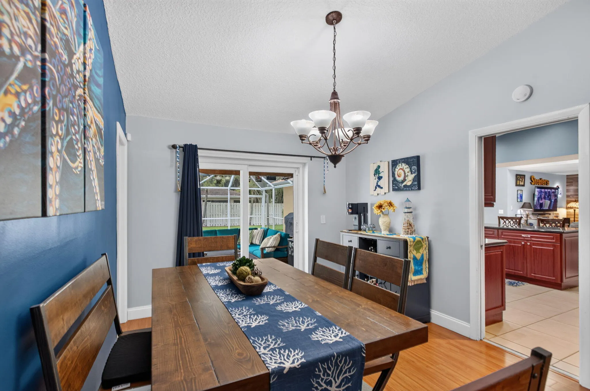 Hardwood flooring throughout, with a classic chandelier illuminating the dining area