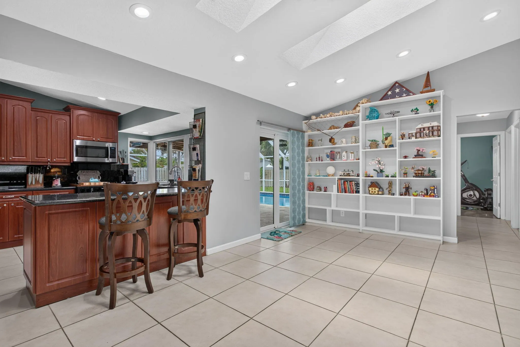 Kitchen island with dark wood cabinetry and black stone countertop