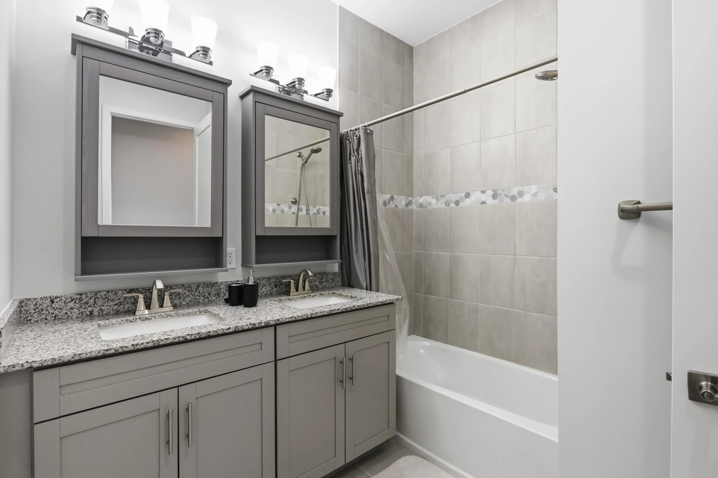 Dual vanity with gray cabinetry, granite-finish countertop, and undermount sinks
