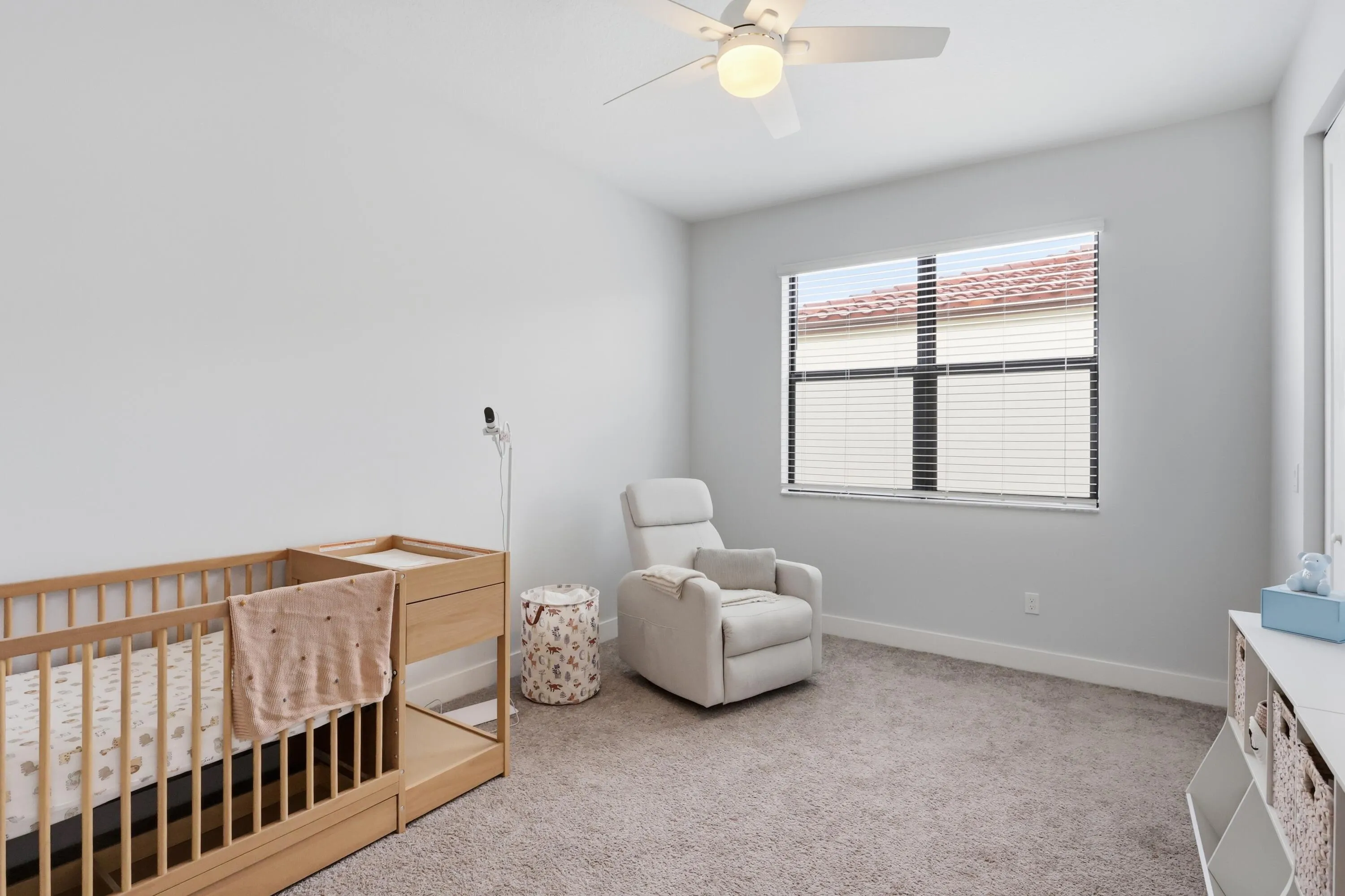 Neutral wall paint, window with horizontal blinds, ceiling fan, and carpet flooring