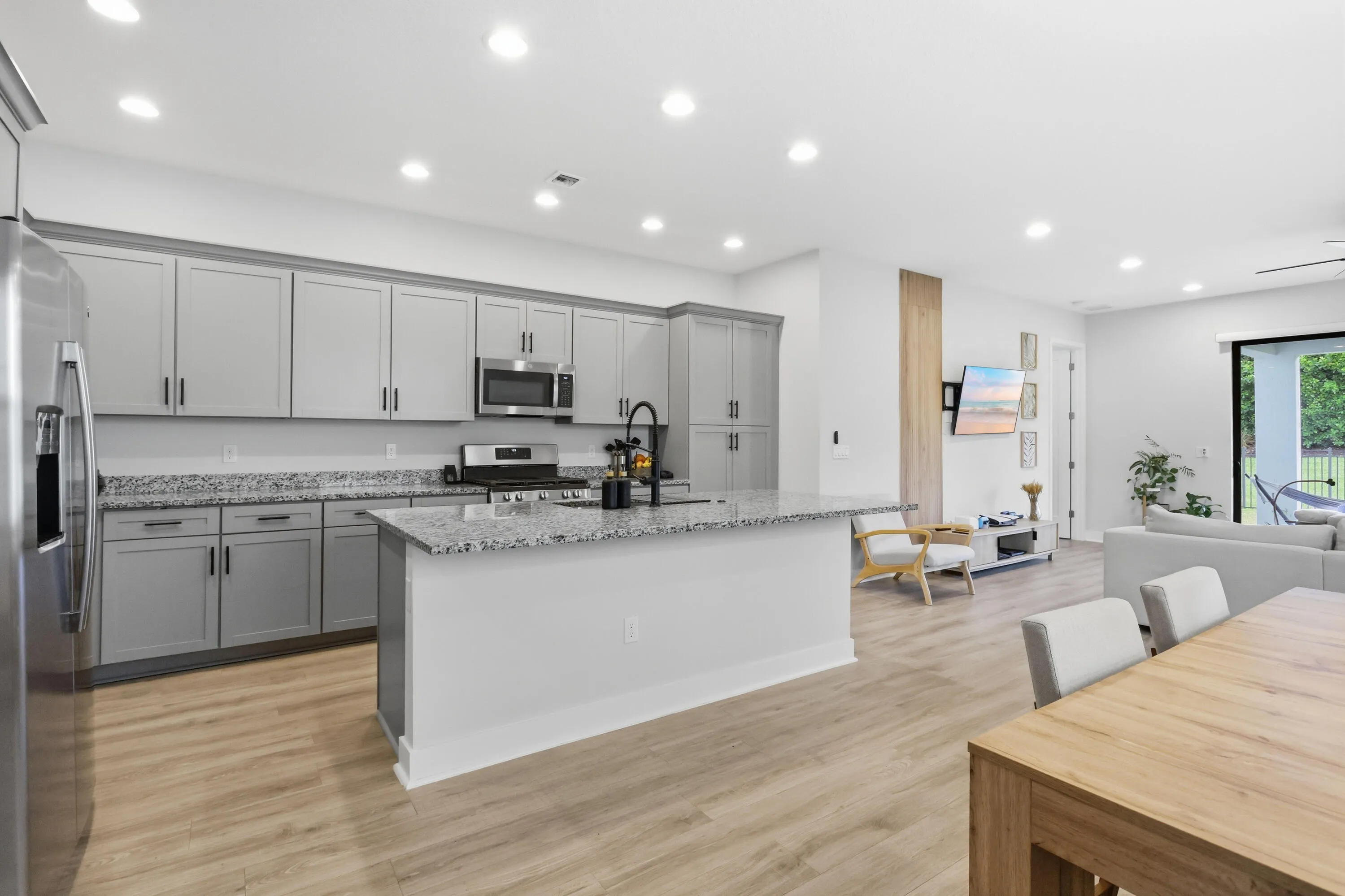 Modern kitchen featuring light gray cabinetry, stainless steel appliances, and granite countertops