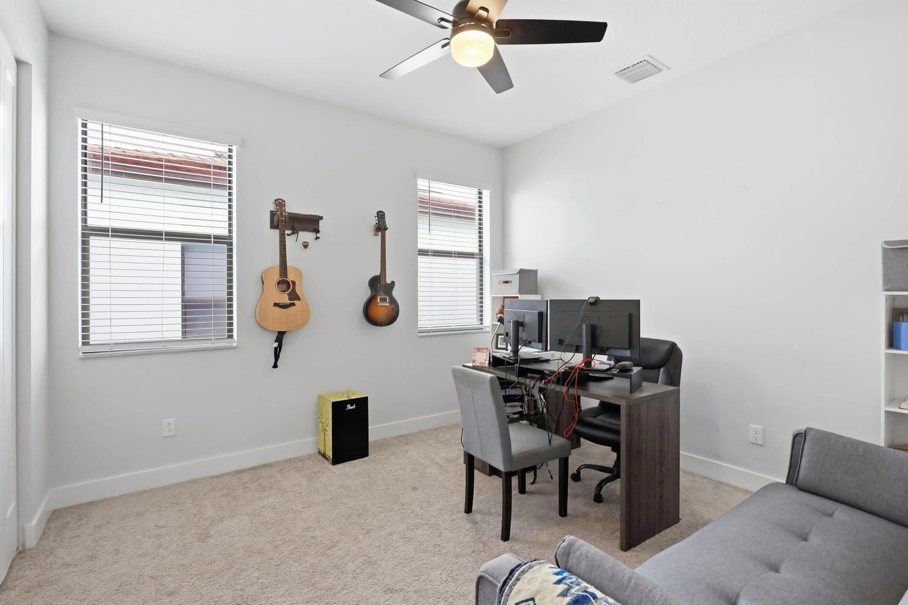 Recessed lighting, ceiling fan, white walls, two windows with blinds, and carpeted flooring