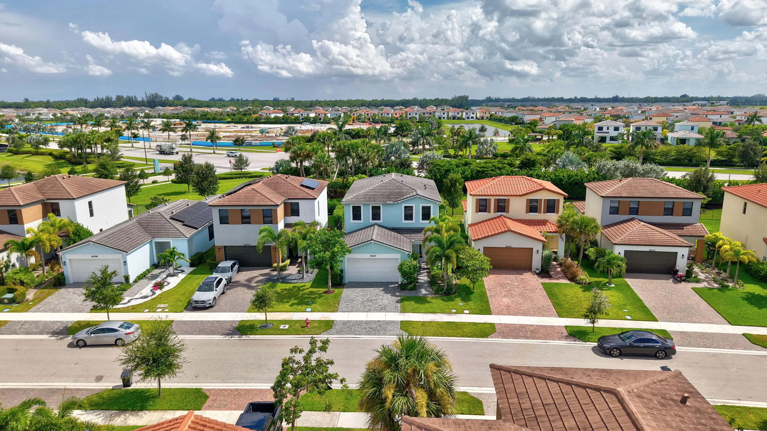 Residential street with a collection of two-story homes, each featuring a private driveway and attached garage