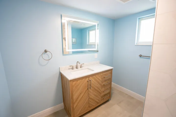 Modern vanity with a rectangular undermount sink, countertop, and an illuminated mirror