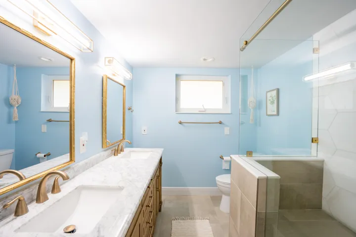 Dual vanity with stone countertop and gold-finish fixtures