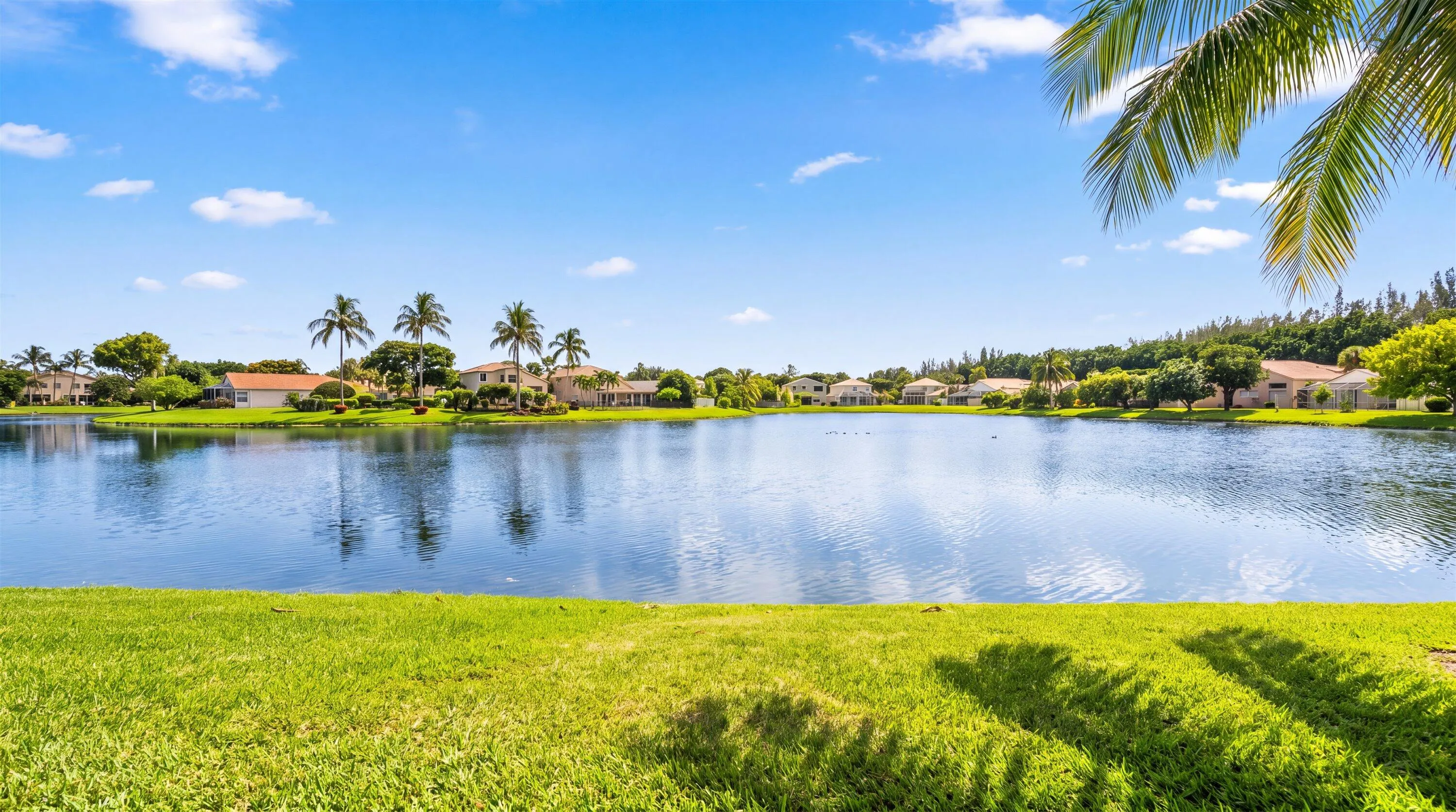 Expansive waterfront property featuring a manicured lawn and mature landscaping