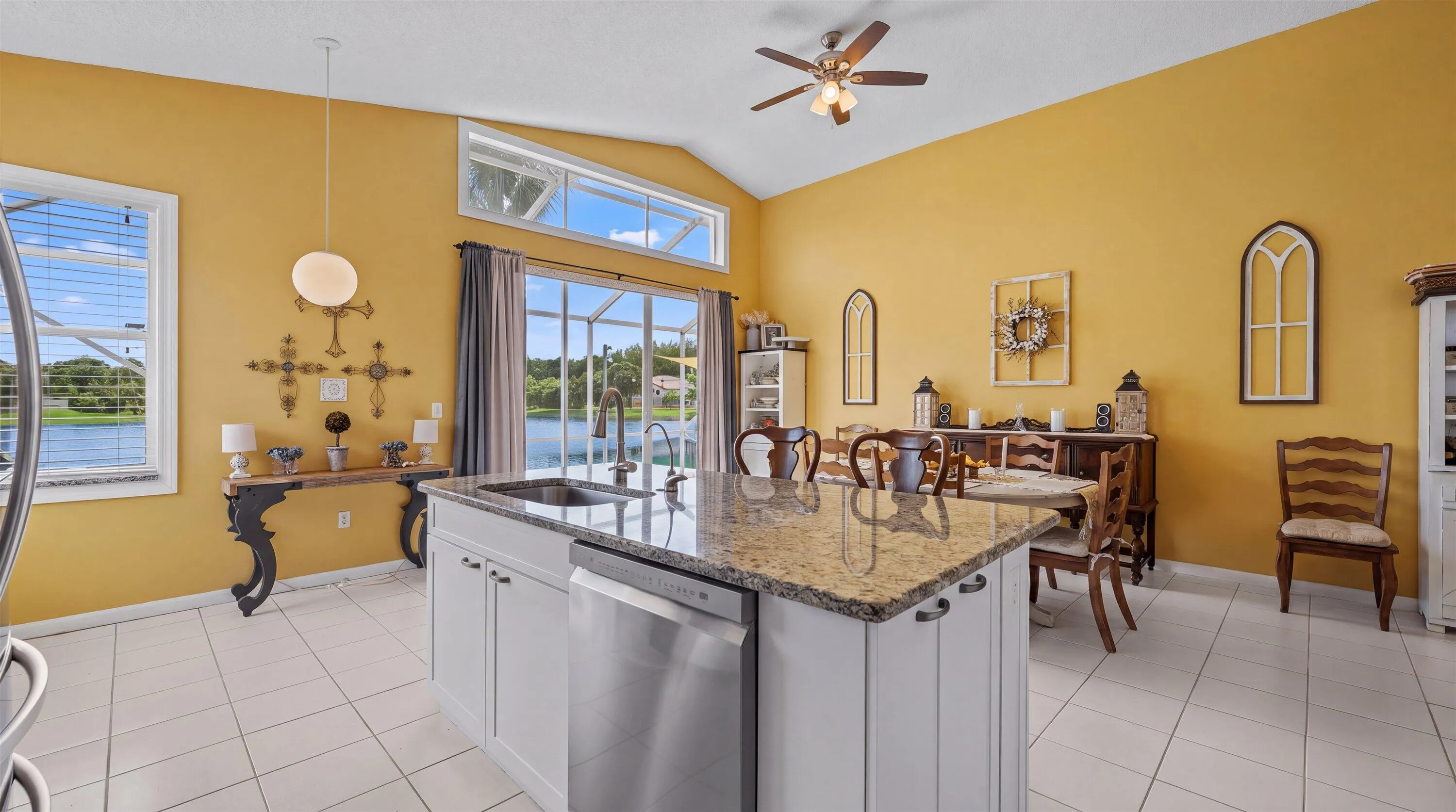 Spacious kitchen with a central island featuring a granite countertop, stainless steel sink, and integrated dishwasher