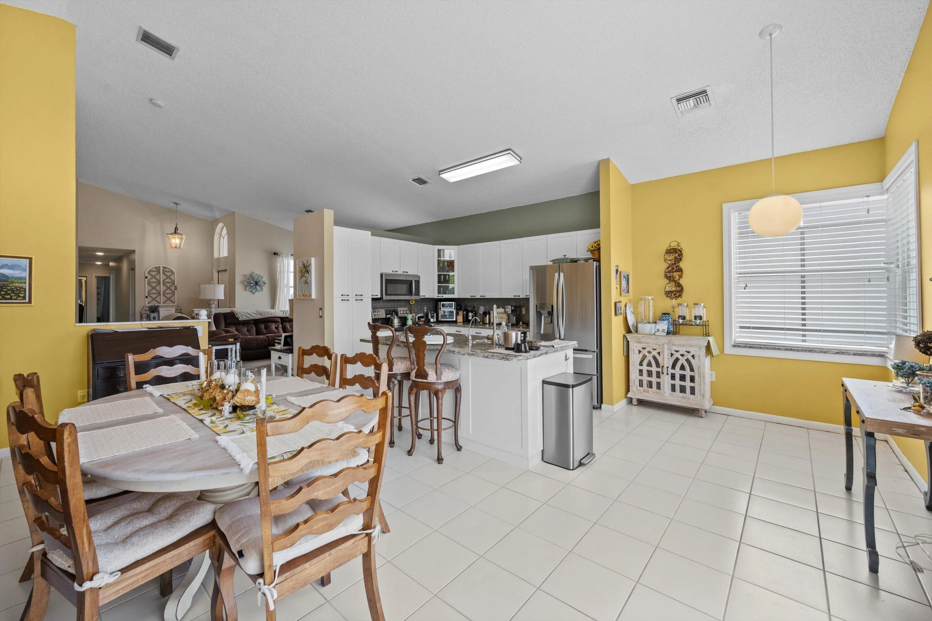 Open-concept living area with tile flooring and vaulted ceilings