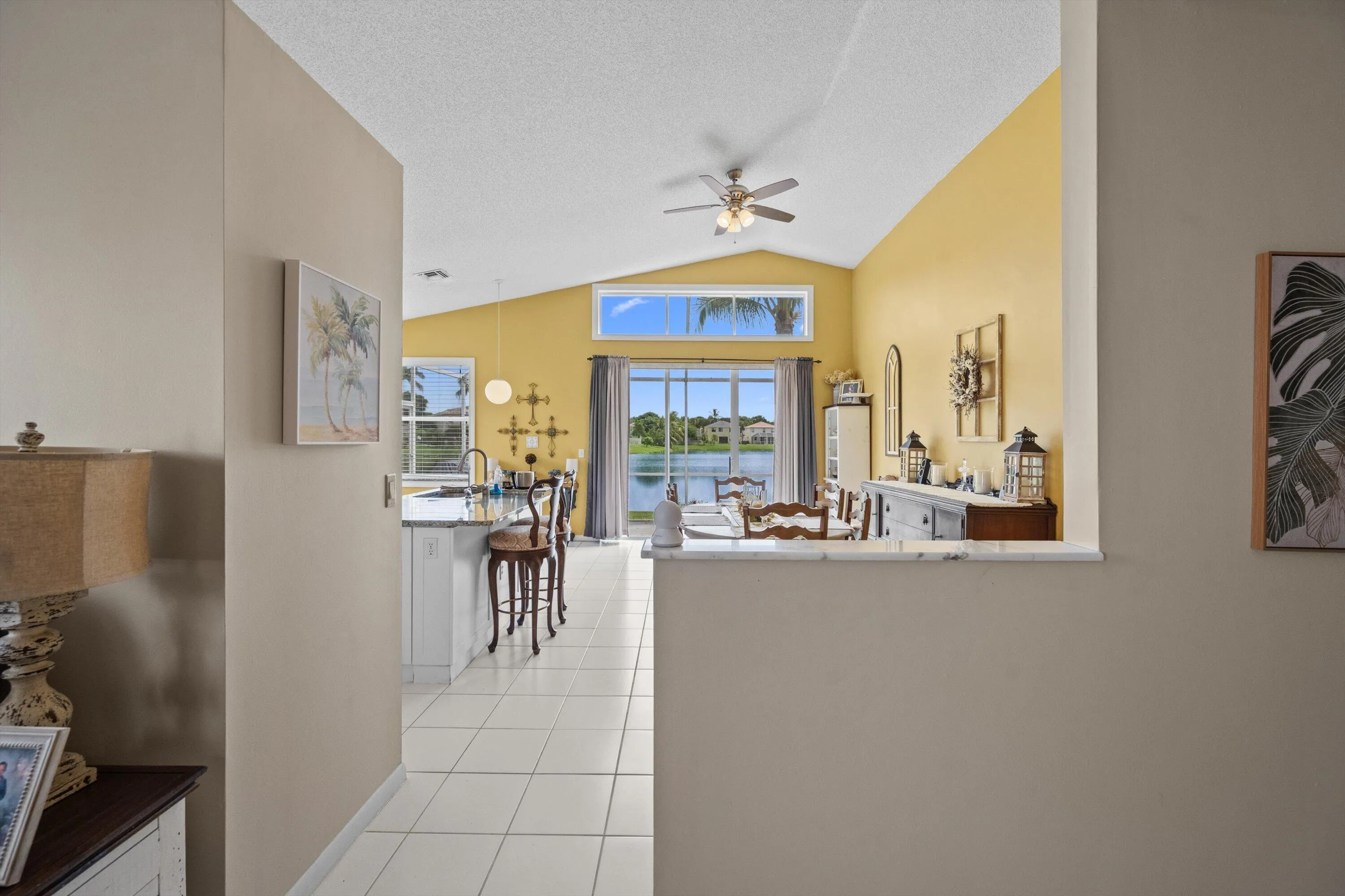 Vaulted ceilings, transom window, and white tile flooring