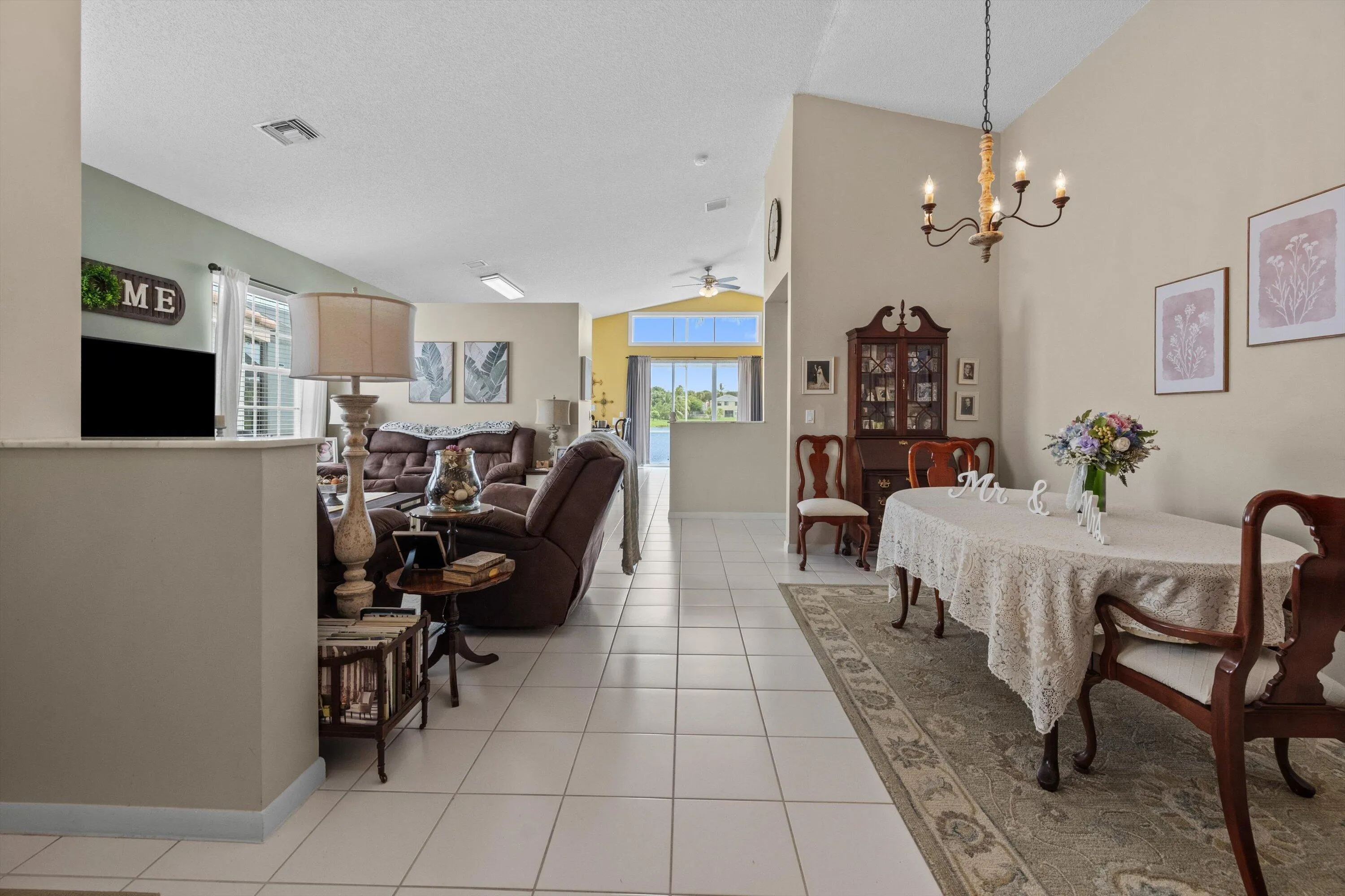 Open-concept living space featuring high ceilings, neutral wall tones, and tile flooring