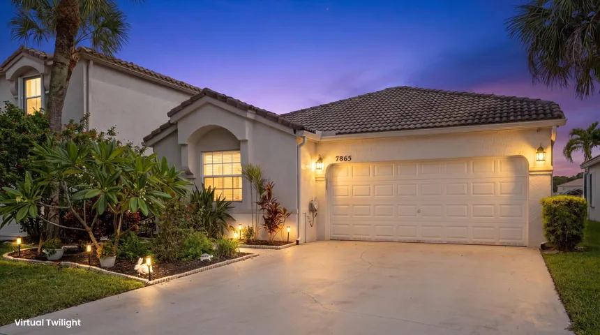 Stucco exterior featuring an arched window, a two-car garage, and a tiled roof