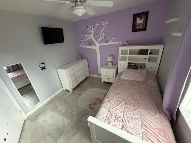 Ceiling fan with integrated lighting, tile flooring, built-in shelving, mounted television, and a full-length mirror