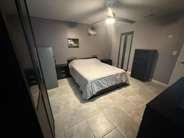 Tile flooring, ceiling fan with integrated lighting, and a closet with bifold doors