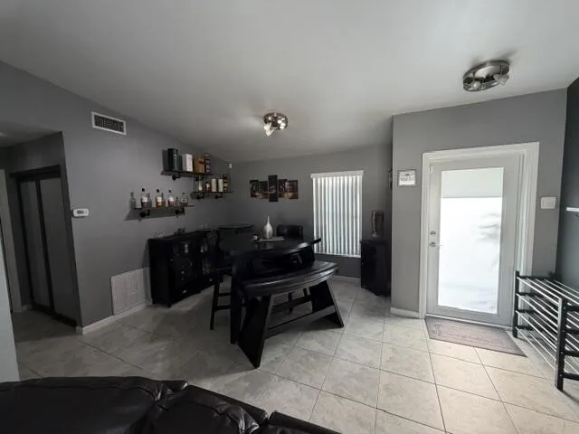 Tile flooring throughout, recessed lighting, and a white framed door with frosted glass