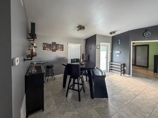 Tile flooring, ceiling-mounted light fixtures, built-in shelving, and a glass-paneled door