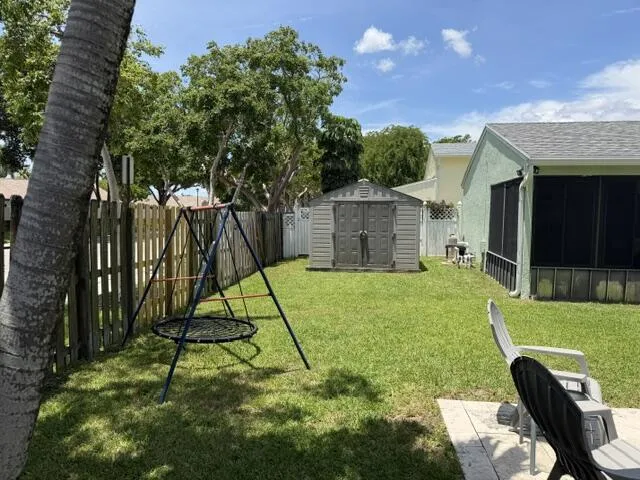 Expansive lawn with a wood fence perimeter and a screened porch