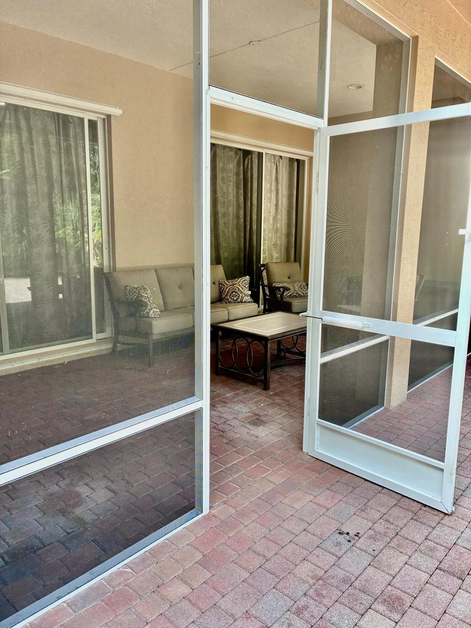 Screened covered patio to open patio in backyard
