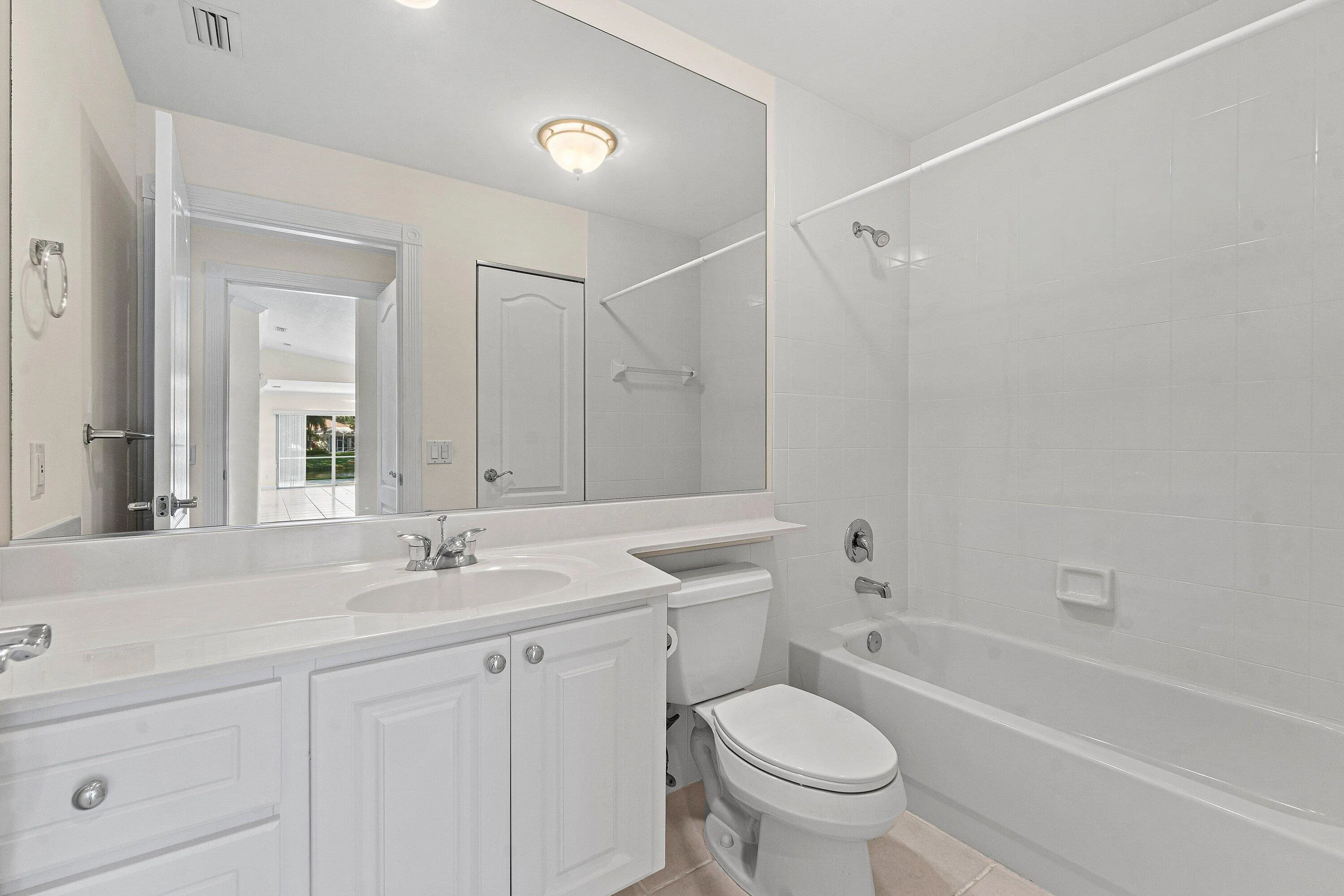 White vanity with shaker-style cabinetry, an integrated sink, and chrome-finish fixtures