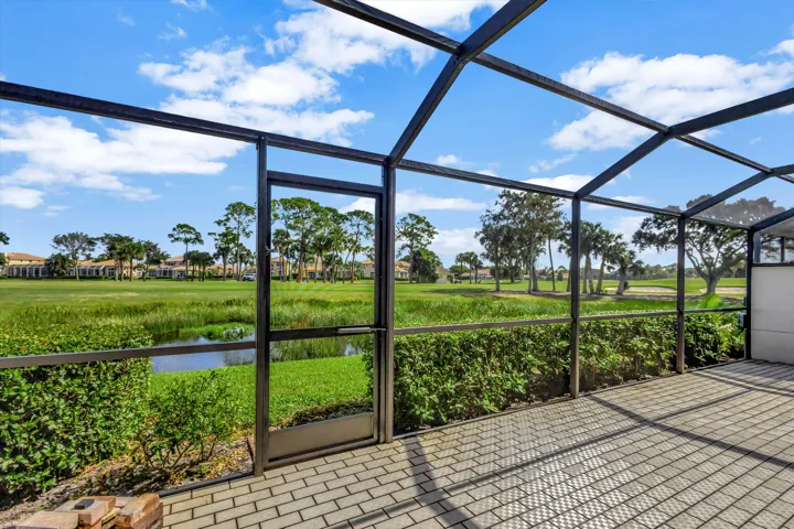 Expansive screened-in patio directly overlooking the water and the renowned Champion Course, offering a peaceful setting to relax and enjoy the beautiful golf and water views.