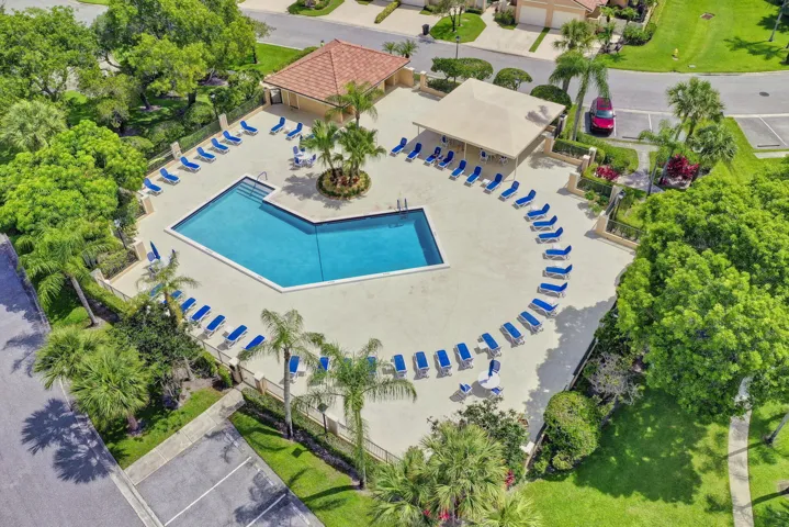 Community pool with ample lounge seating, a covered pavilion, and surrounding mature landscaping