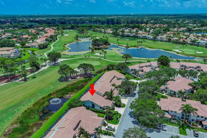 Golf course frontage with a water feature, surrounded by mature landscaping and residential structures