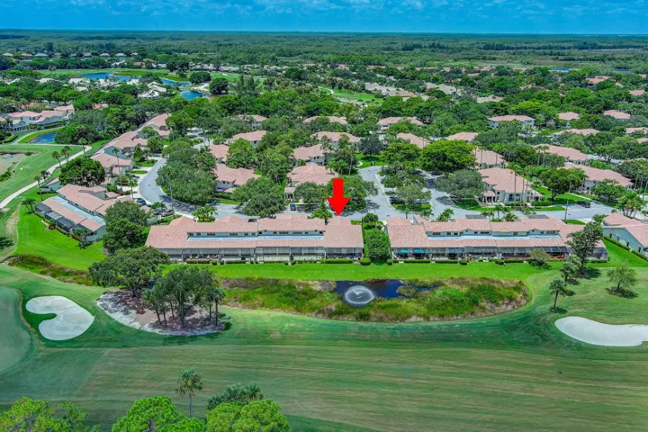 Residential community with mature landscaping, golf course frontage, and a central water feature with fountain