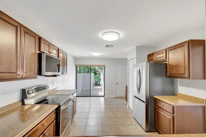 Spacious, light-filled kitchen with room for a breakfast table and sliding glass doors that open to the outdoor area, perfect for enjoying morning coffee or casual meals.