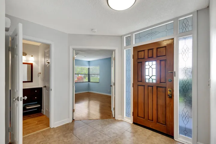 Wood front door opens to the main foyer, with the guest bedroom and a full bathroom conveniently located just to the right.