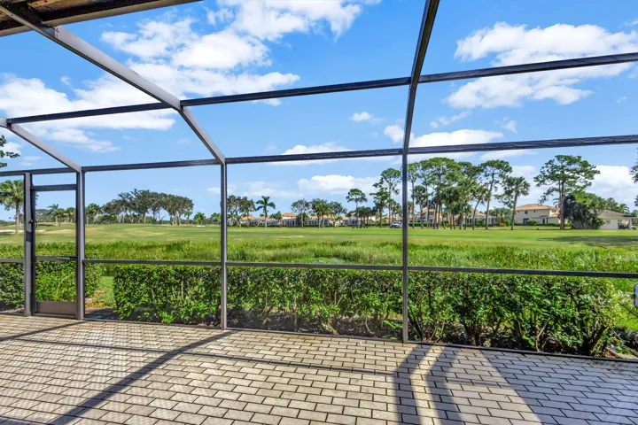 Another angle from the screened patio showcases the lush green landscape of the Champion Course, with expansive fairway views creating a serene and picturesque backdrop.