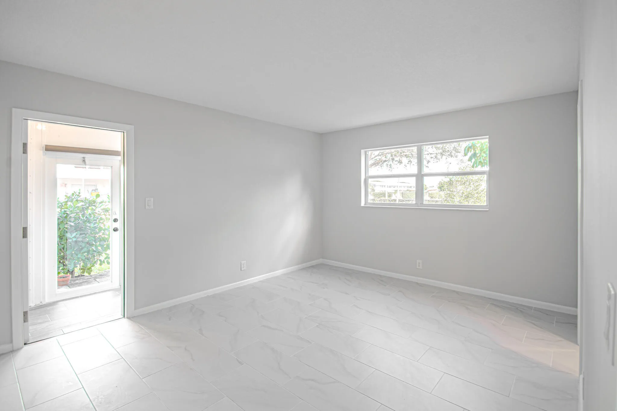 Large Master Bedroom with Windows and Access to the Back Patio