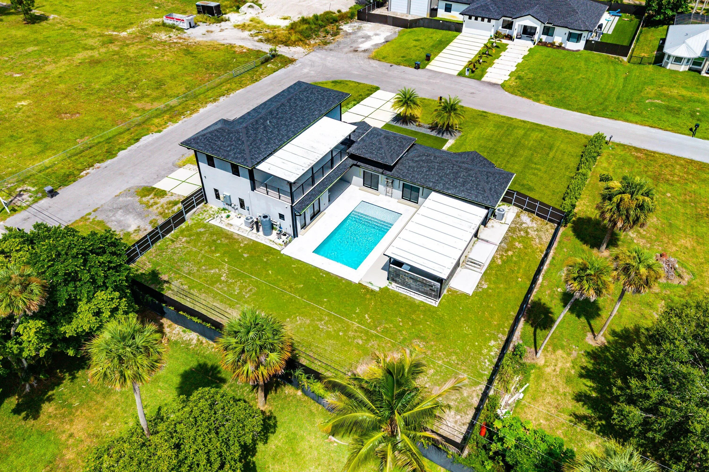 Modern two-story residence with a dark shingle roof and light gray exterior