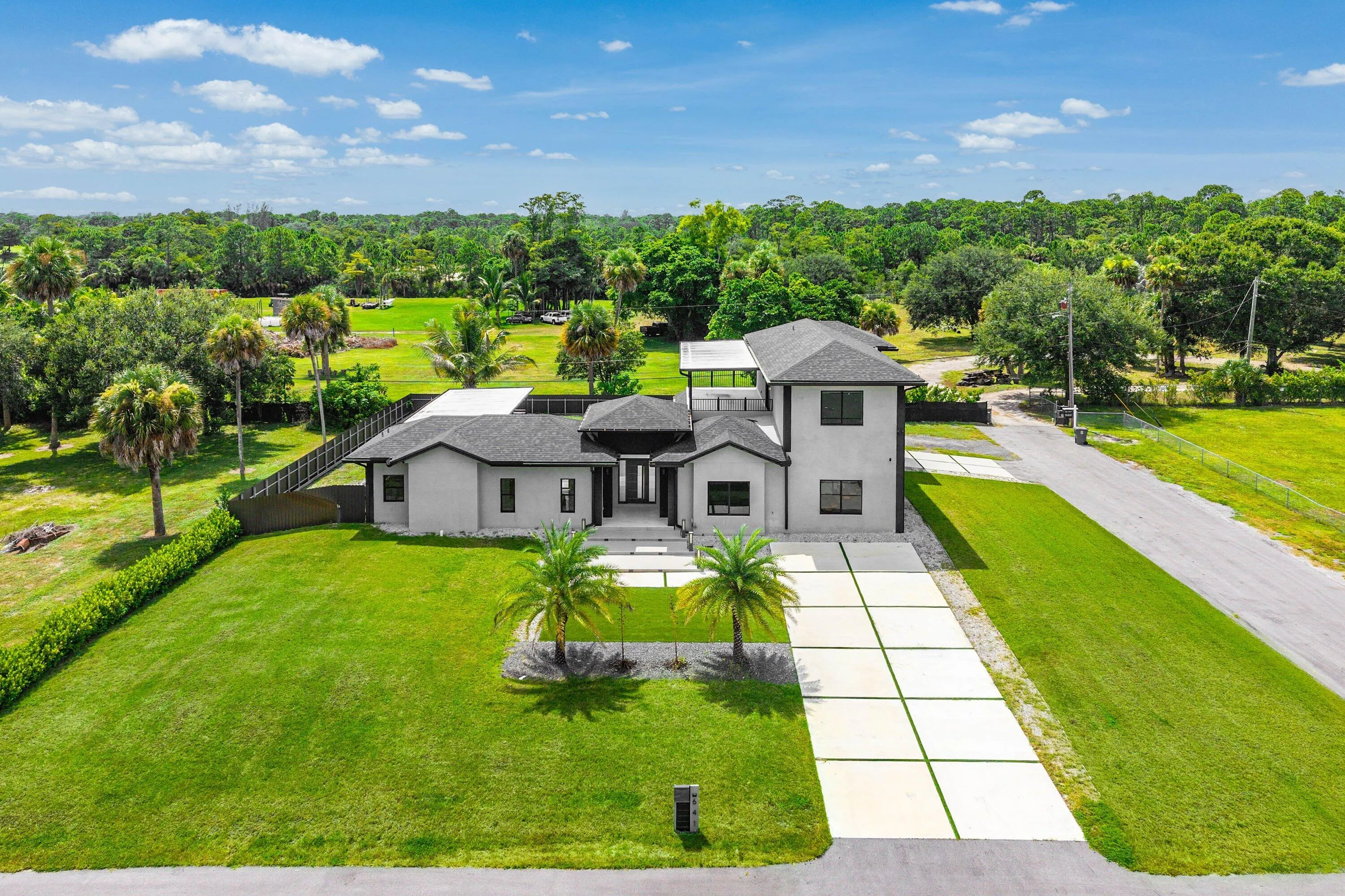 Contemporary architecture featuring a stucco exterior, dark trim windows, and a multi-level design