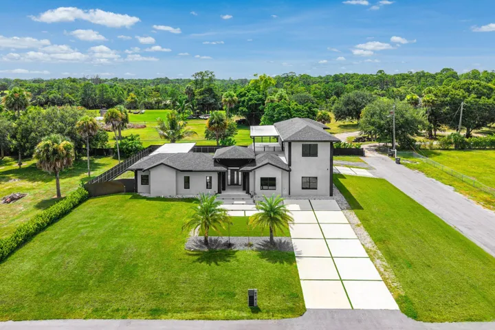 Contemporary architecture featuring a stucco exterior, dark trim windows, and a multi-level design