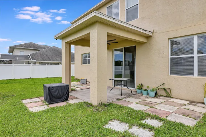 Covered patio space, sliding glass door, multiple exterior windows, and a fully fenced yard